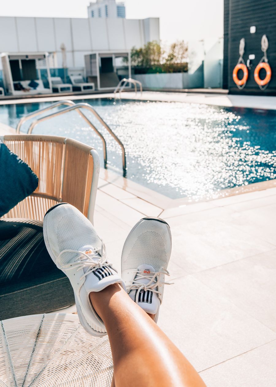 white sneakers on holiday lying by a pool