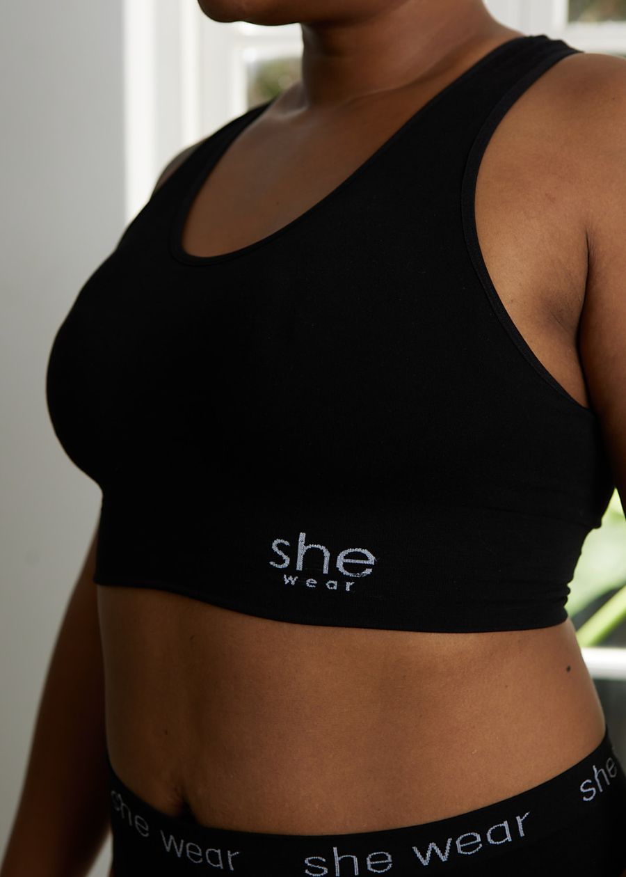 Side view of woman in a black soft-cup crop top bra and briefs made of stretchy organic bamboo by an Australian company.