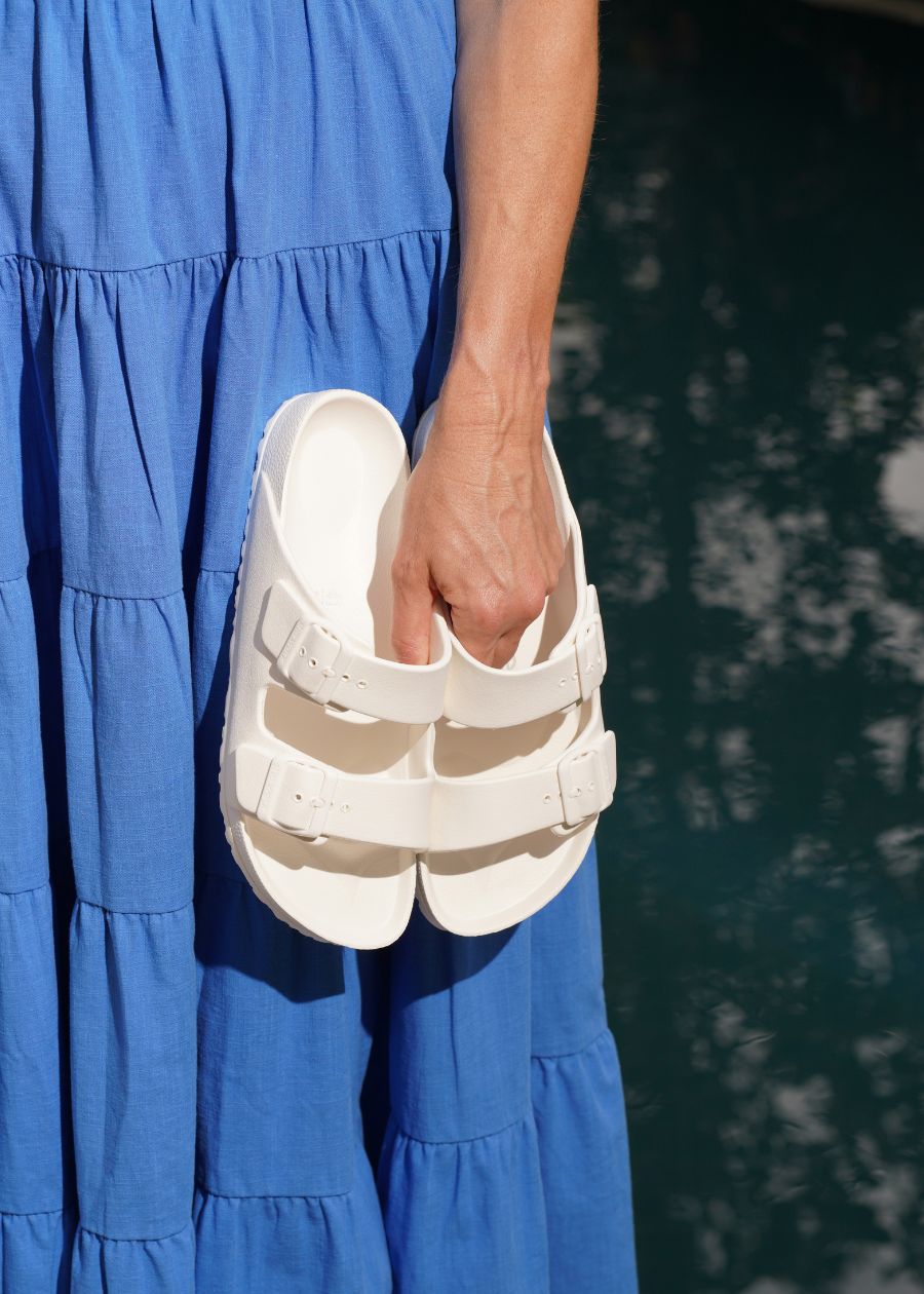 Woman holding white waterproof slides.