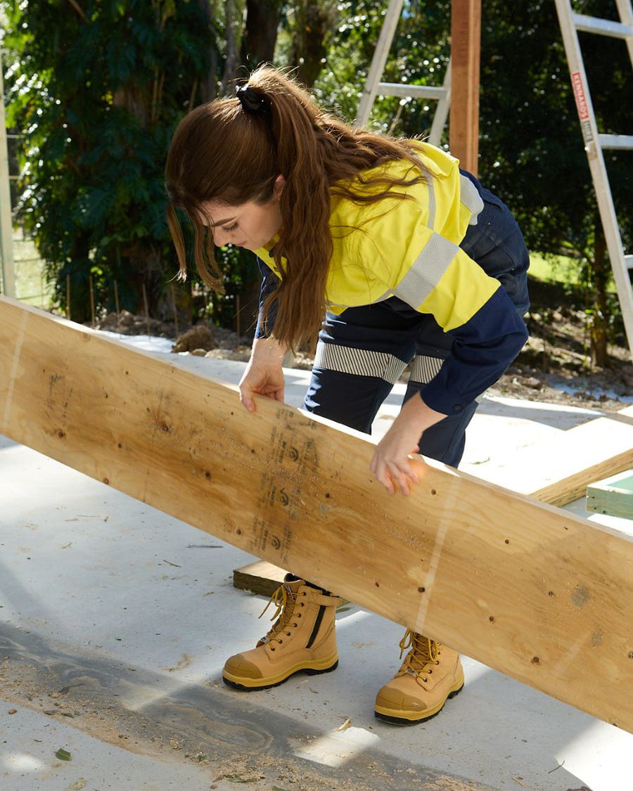Woman doing construction work in wheat coloured safety boots.