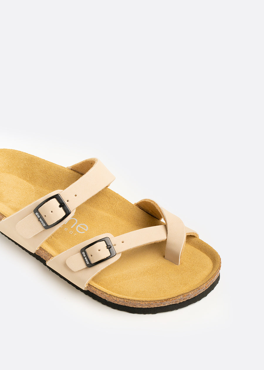 Contoured leather footbed of a tan slide