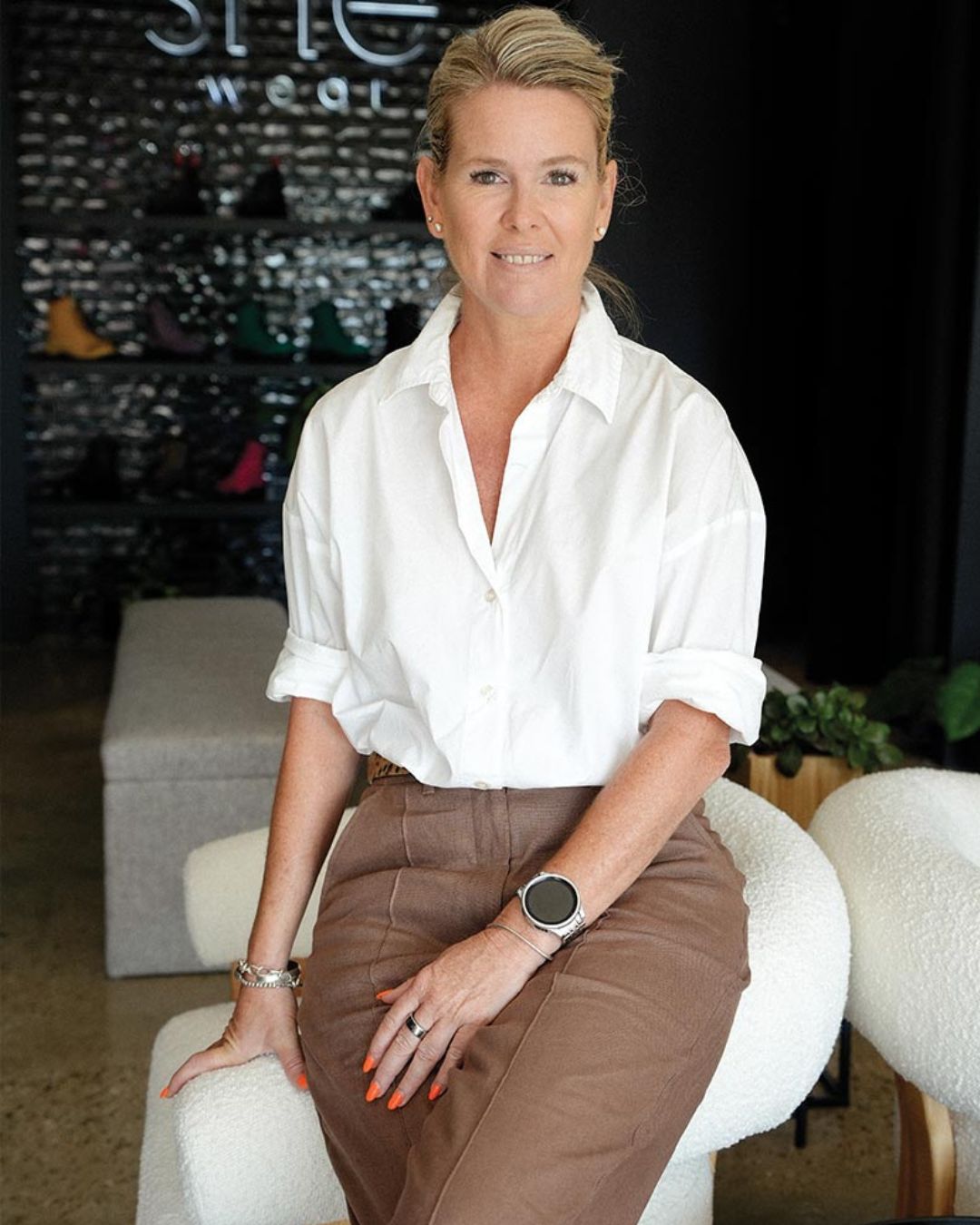 Founder, Stacey Head, sitting in retail store facing the camera.