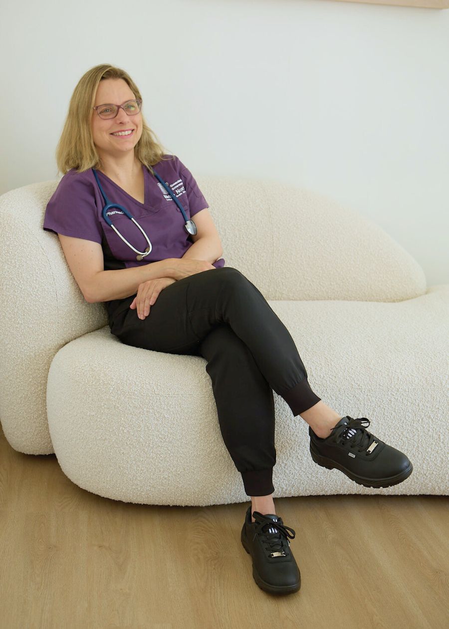 nurse in scrubs wearing supportive and comfortable black water resistant work shoes