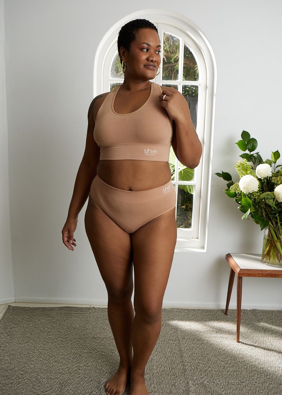 Woman smiling in front of window wearing warm toned bamboo underwear set