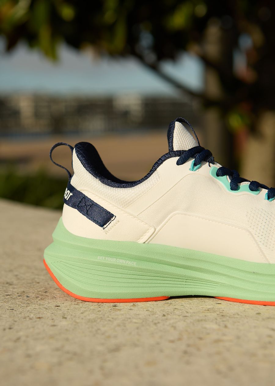 heel detail of the Pace walking shoe with green sole, white upper and navy blue accents