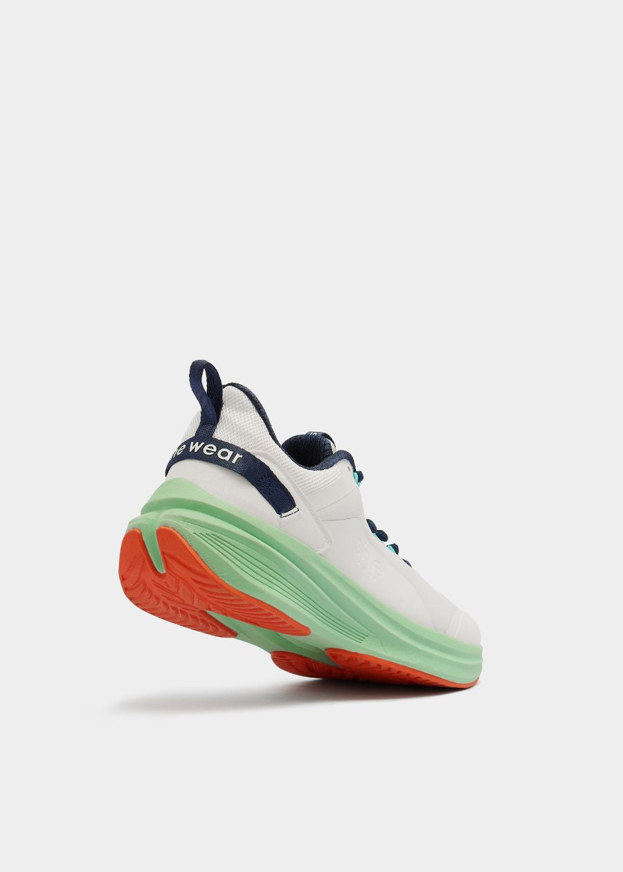angled view of white and mint green walking shoe, orange accents on sole