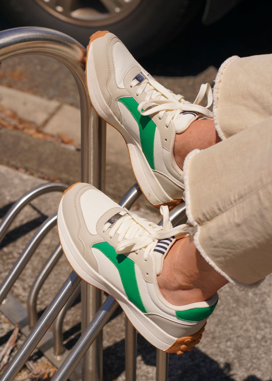 White fashion sneakers with tan and green detailing, comfortable and supportive for all-day wear