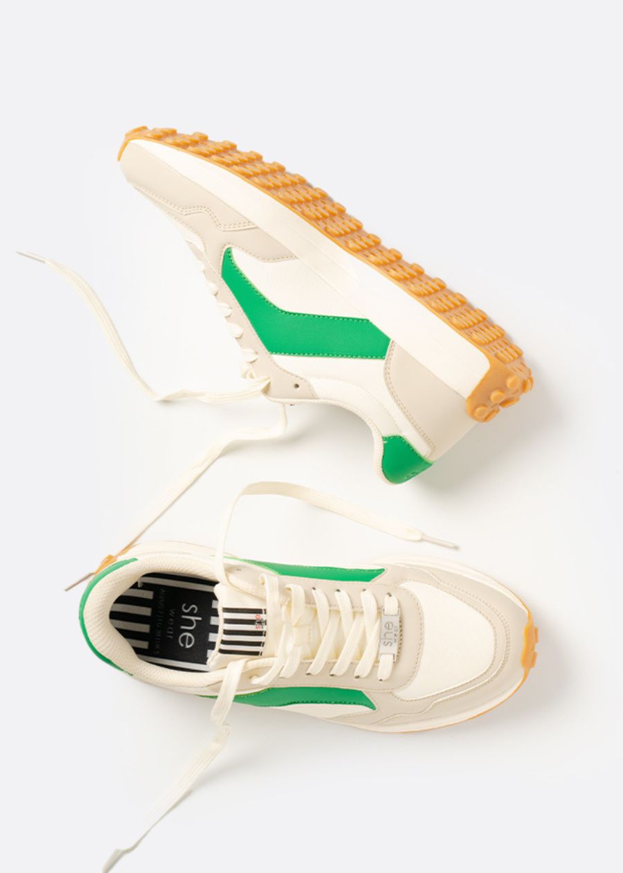 Laces askew, a fashionable pair of green tan and white sneakers