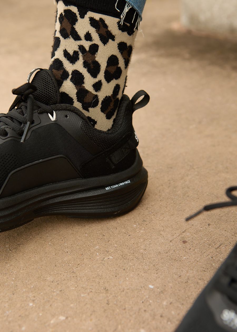 Close up of heel on black coloured walking shoes, with leopard print socks