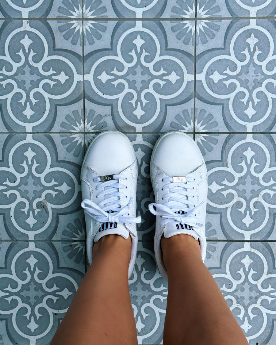 white fashion sneakers on grey tiles