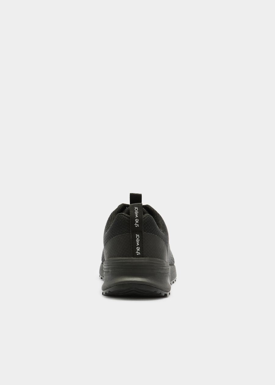 Rear view of she wear Thrives women's black safety shoe with heel loop and mesh-textured upper
