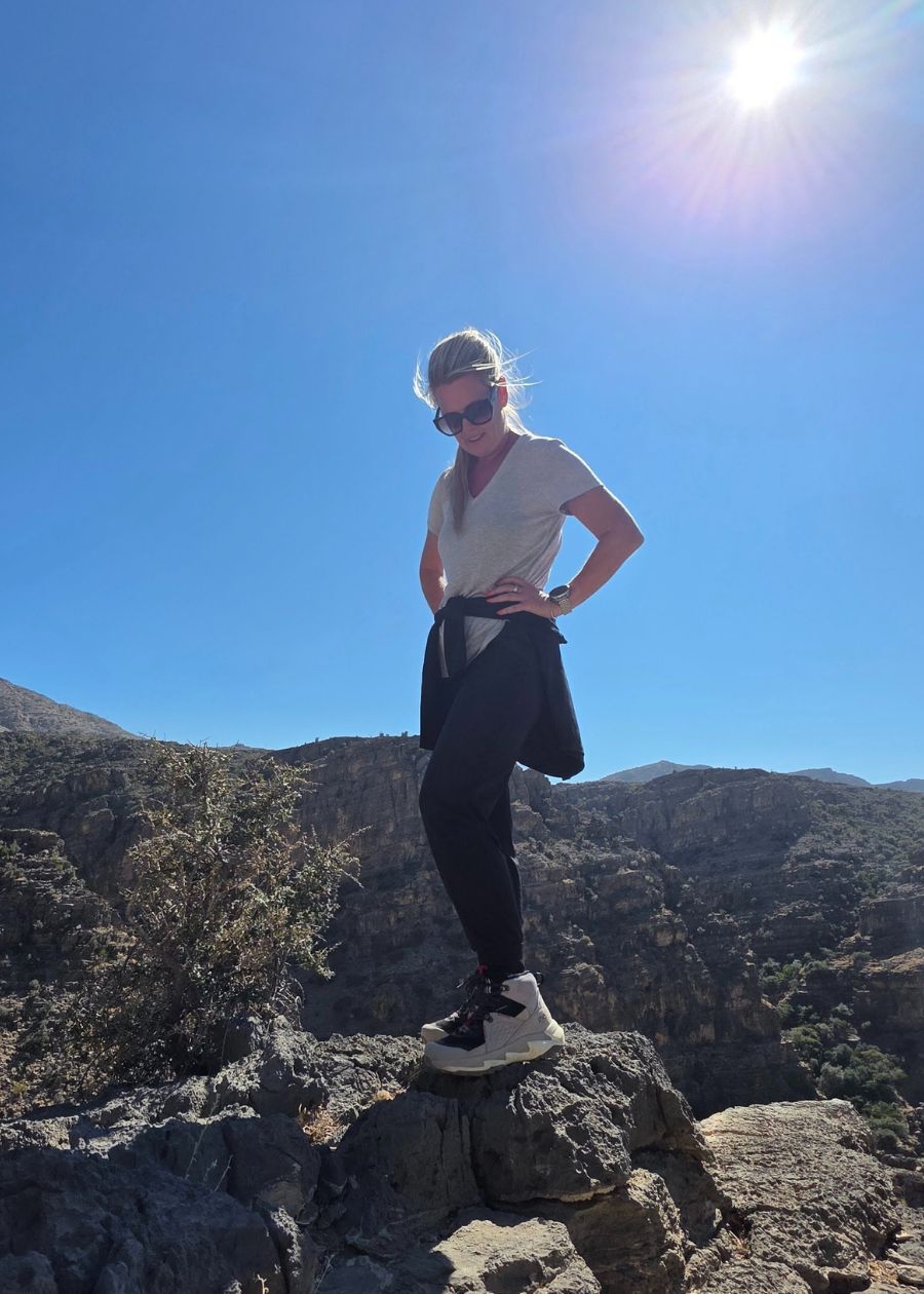 Standing on cliff side in black and grey ankle hiking boots.