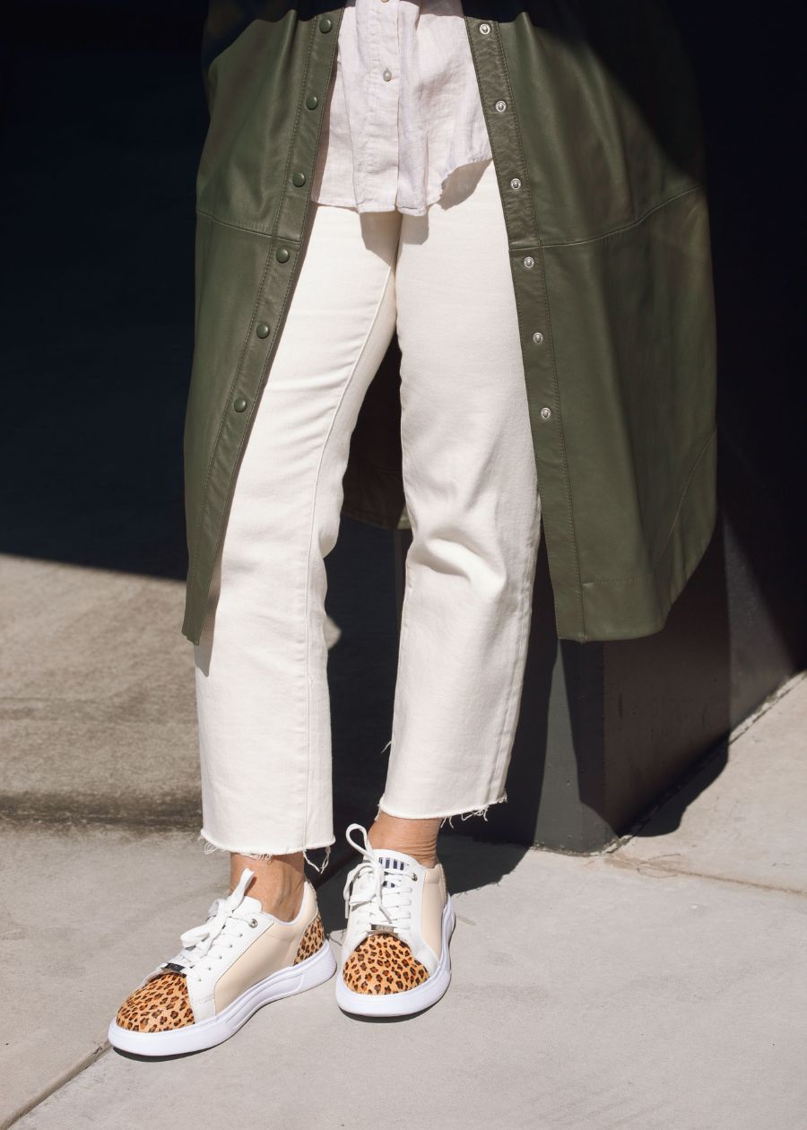 leopard print supportive sneakers with white jeans and khaki jacket