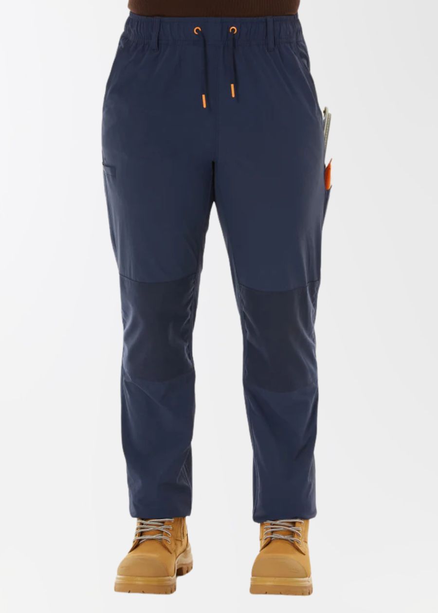 A woman's lower half, wearing navy work pants with drawstring and tan work boots