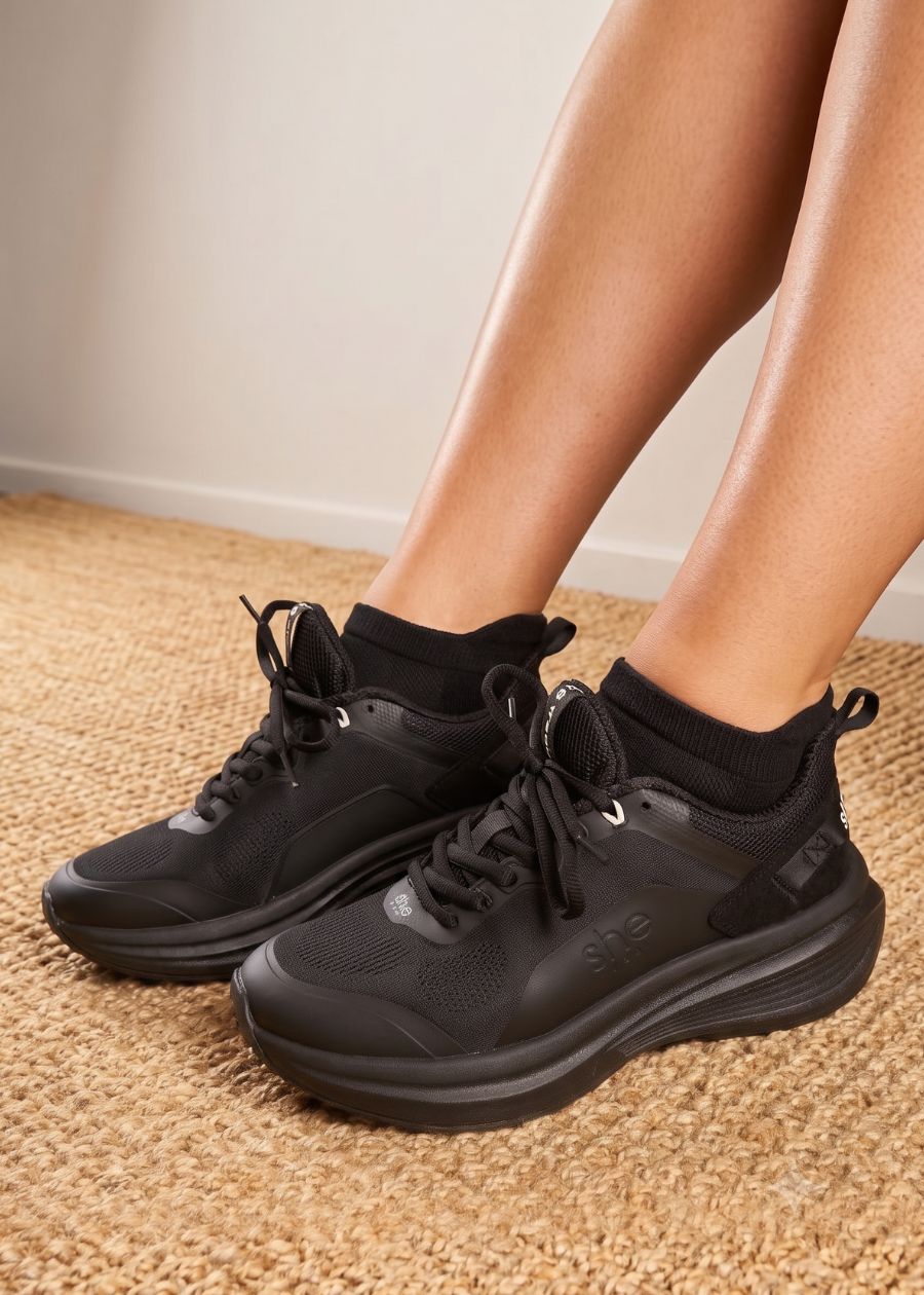 a pair of black walking shoes being worn with a black pair of ankle socks