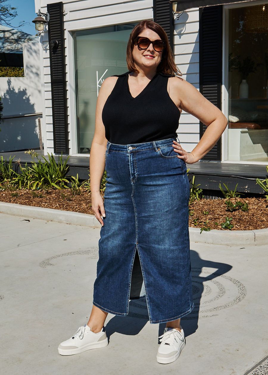 woman in black top and navy skirt wearing stylish she wear rise white sneakers