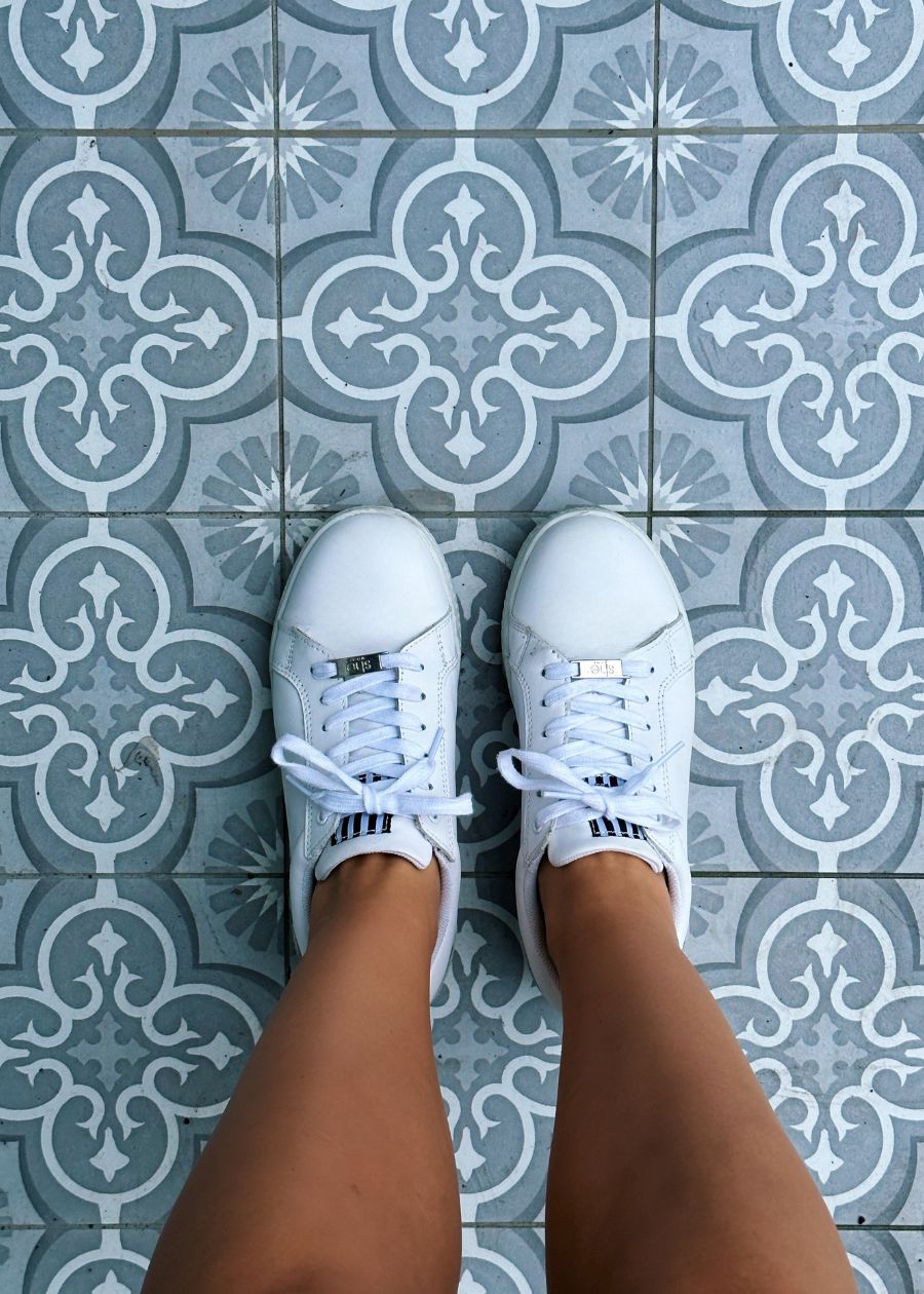 white fashion sneakers on grey tiles