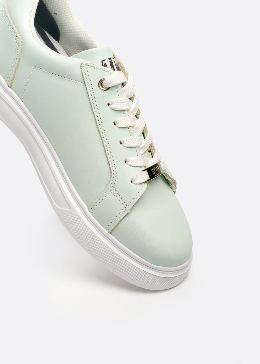 A mint coloured leather sneaker with white laces and a white slip resistant sole