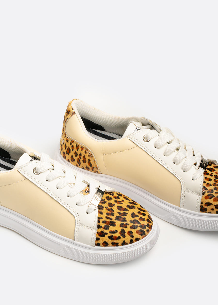 A pair of leather sneakers with leopard print fur on the toe and heel